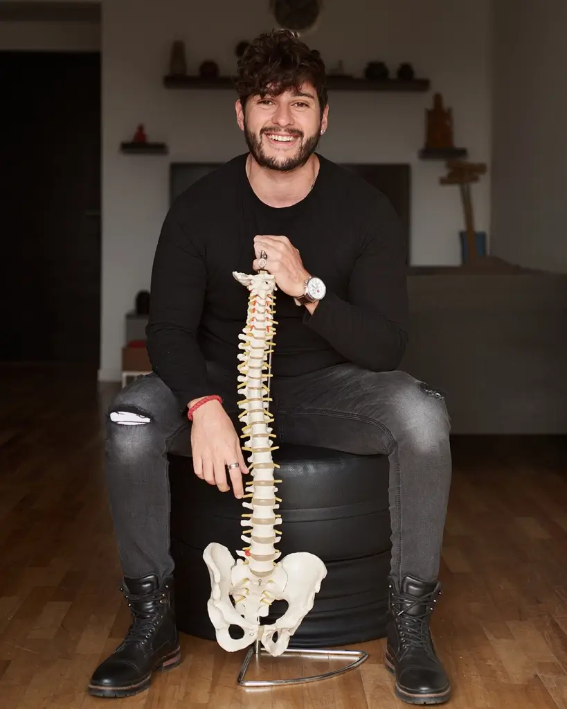 Foto de Adrián Atienza sosteniendo una réplica de una columna vertebral